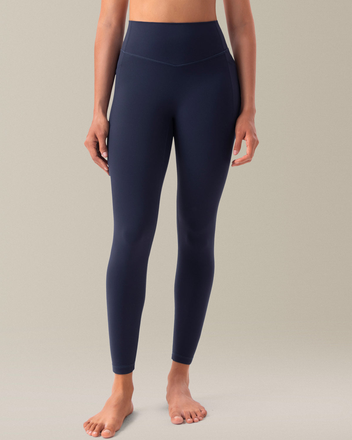 YUNOGA HugMotion women's high-waisted leggings in navy blazer, featuring no front seam design and side pockets.